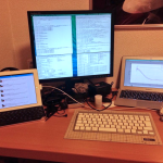 Twitter on iPad on the left, laptop with two screens on middle and right.